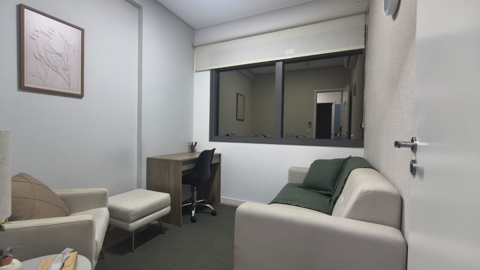 Sala 1 mobiliada com poltrona, puff, sofá e mesa de trabalho